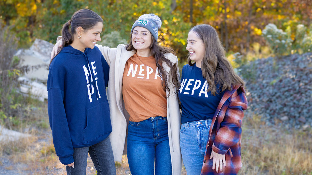 Models wearing NEPA Store products: Navy Stacked Hoodie, Heather Autumn Classic Tee, Navy Classic Long Sleeve